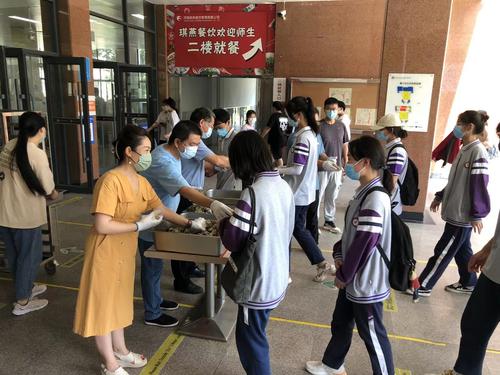 郑州艺术幼儿师范学校利用午餐时间给学生发放粽子
