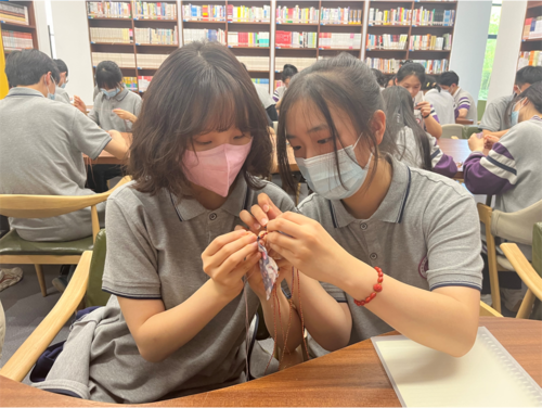 同学们互相合作缝制香囊