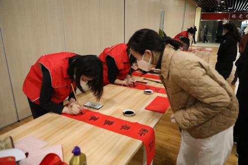 5小红帽志愿者认真书写春联