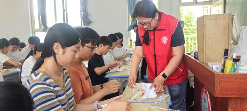 4郑州艺术幼儿师范学校教师赵晨和学生一同展示扎染成果